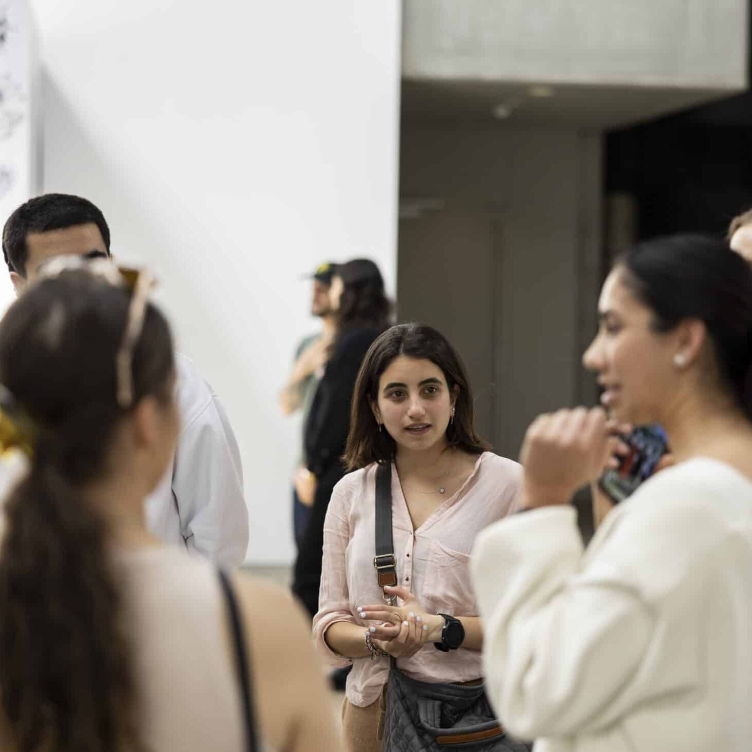 A group of young people talking to each other in the foyer of an event.